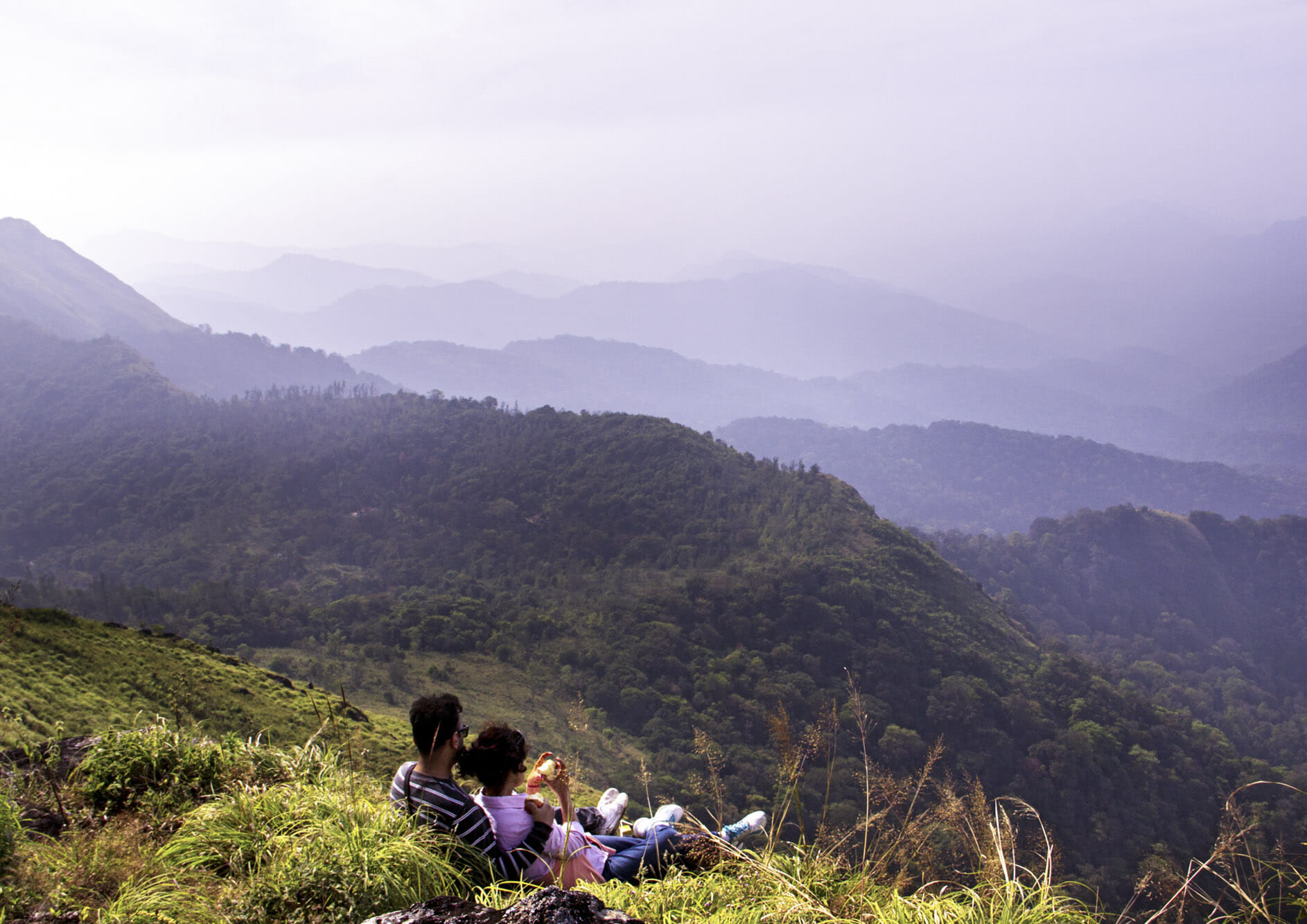 young-couple-at-top-of-a-mountain-and-enjoying-the-view-of-valley