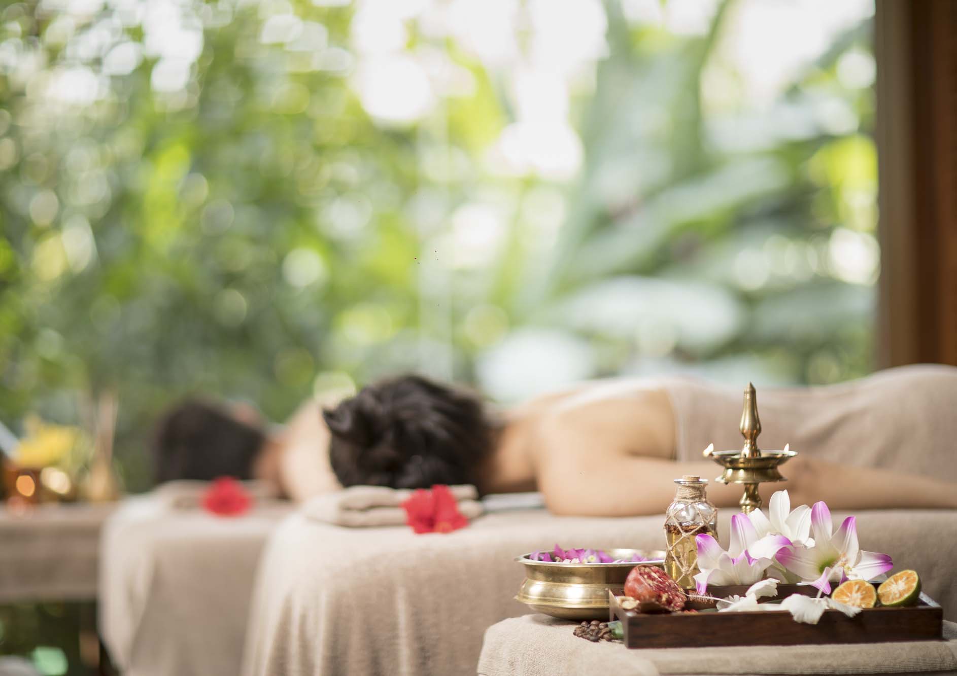Young-man-and-woman-lying-down-on-massage-beds-at-Asian-luxury-spa-and-wellness-center
